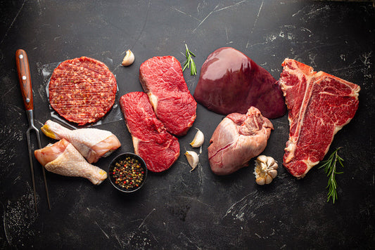 Selection of raw meat for carnivore diet including beef steak, ground beef, heart, liver and chicken