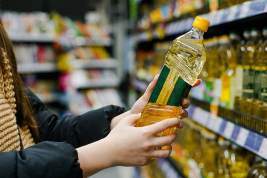 Woman choosing sunflower oil in the supermarket aisle
