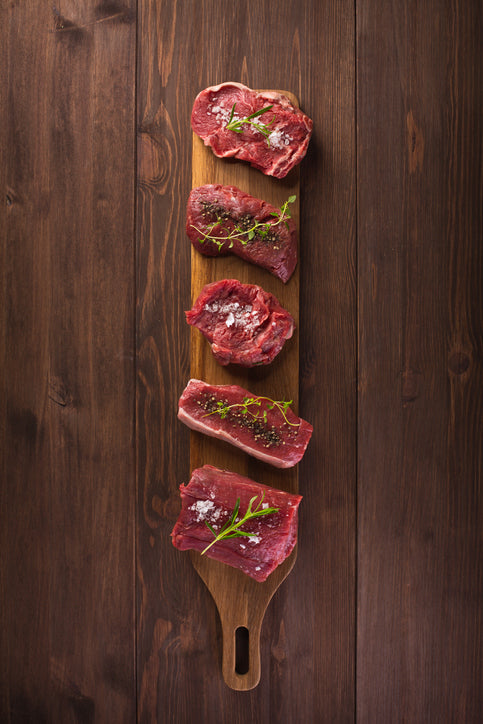 Variety of grass-fed beef cuts including ribeye steak, NY Strip, Sirloin Steak, Filet Mignon